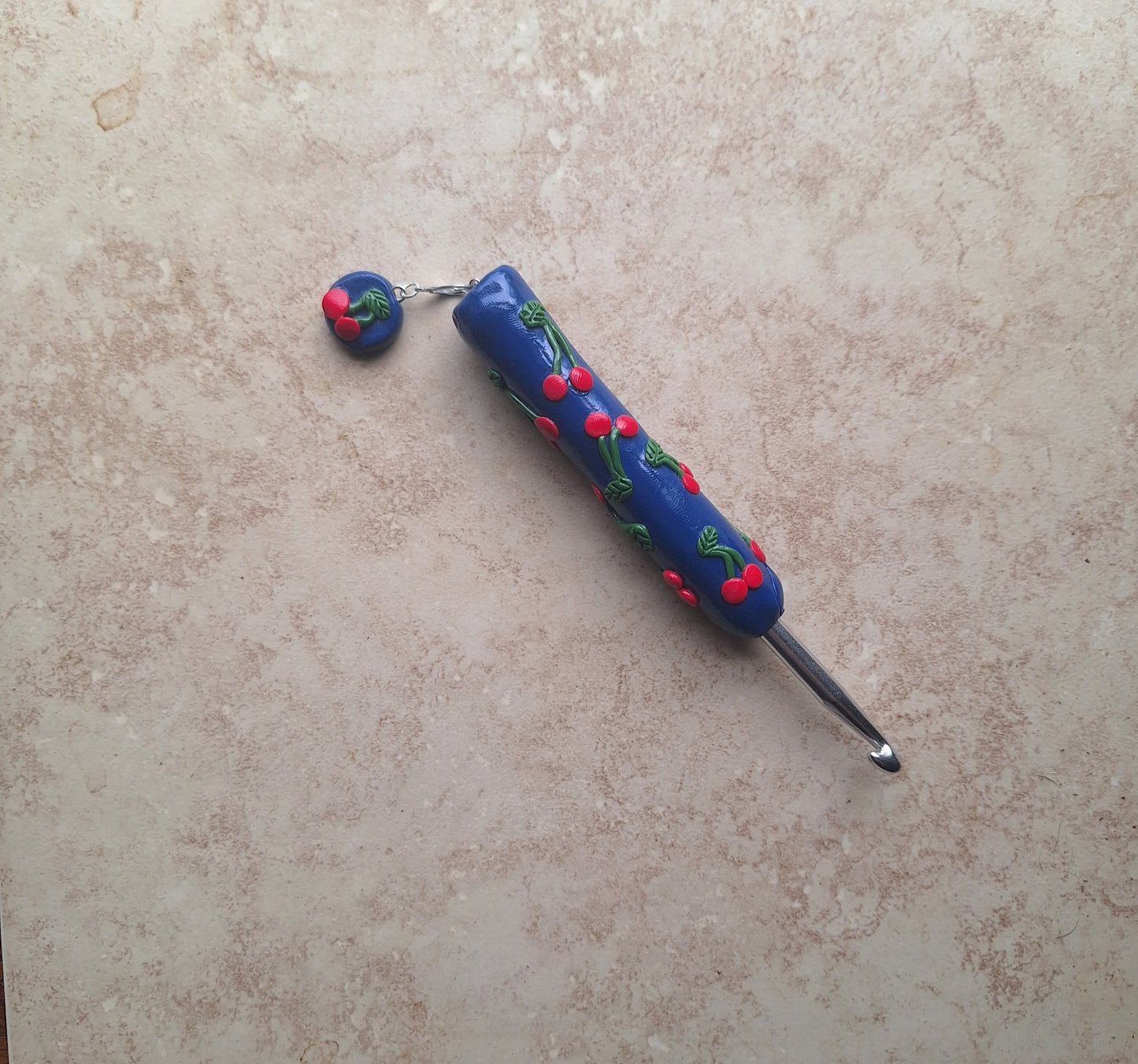Polymer clay fruit cherries on navy crochet hook with stitch marker