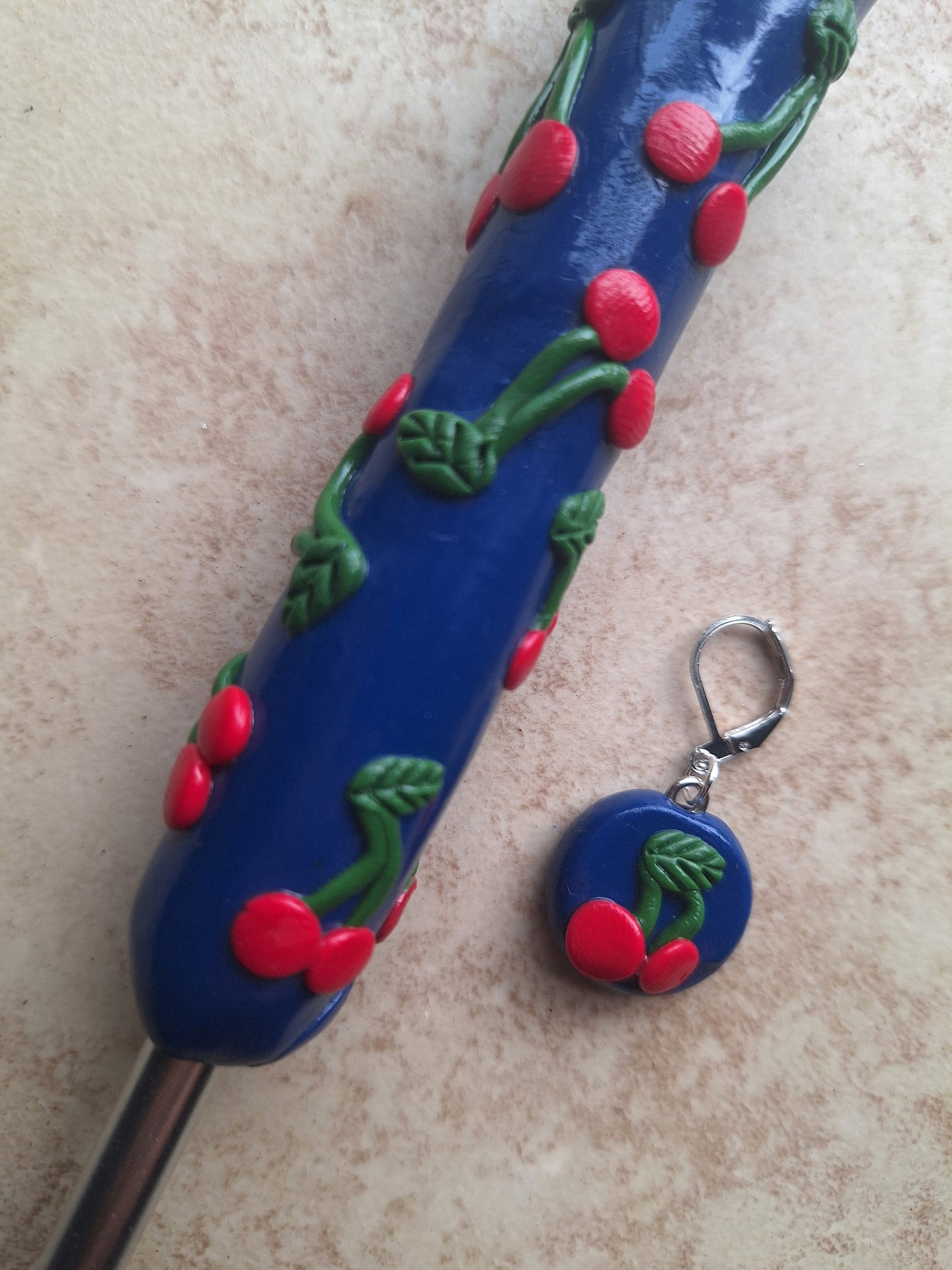 Polymer clay fruit cherries on navy crochet hook with stitch marker