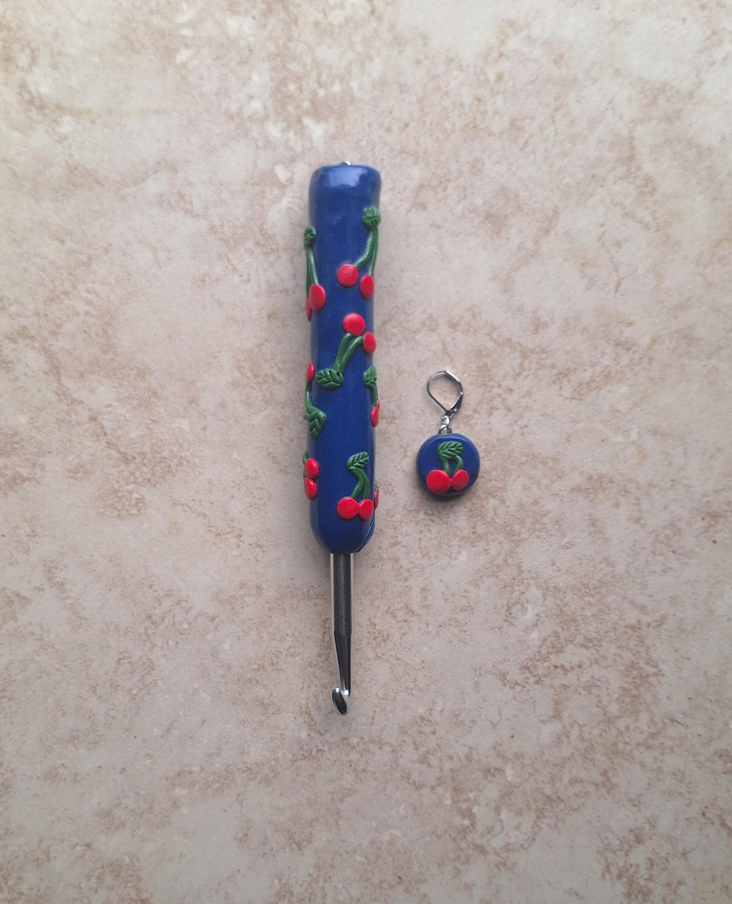 Polymer clay fruit cherries on navy crochet hook with stitch marker